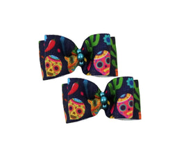 Two colorful hair bows with skull designs on a white background