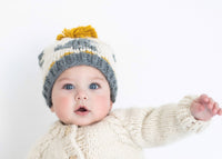 Baby wearing a knitted outfit with a white background