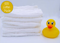 Stack of white cotton muslin with a yellow rubber duck on a light gray background