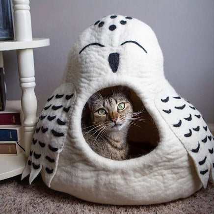 Cat peeking out from a white pet bed shaped like an owl