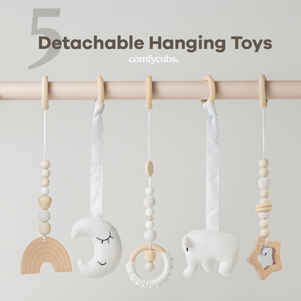 Detachable hanging toys with wooden and fabric elements on a rod against a light gray background.