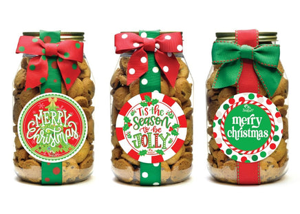 Three jars of dog treats with Christmas-themed labels and bows on a white background
