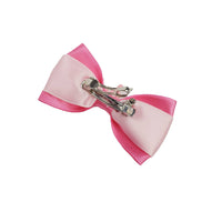 Pink and white bow hair clip on a white background
