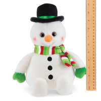 Plush snowman toy with a black top hat and striped scarf next to a ruler on a white background