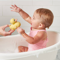 Baby in a bathtub with a yellow rubber duck