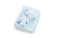 Blue textured blanket with a small teddy bear on a white background