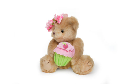 Teddy bear with a pink flower headband and cupcake plush toy on a white background