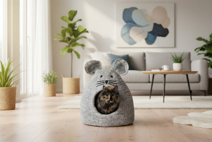Cat inside a gray mouse-shaped pet bed on a white background