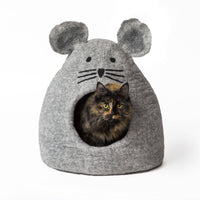 Cat inside a gray mouse-shaped pet bed on a white background