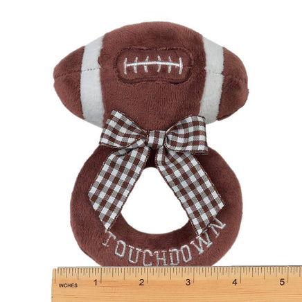 Plush football-shaped toy with a bow and 'Touchdown' text, accompanied by a ruler for scale.