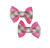 Two plaid hair bows with pink edges on a white background
