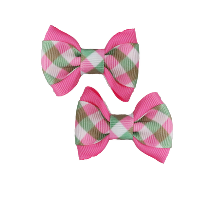 Two plaid hair bows with pink edges on a white background