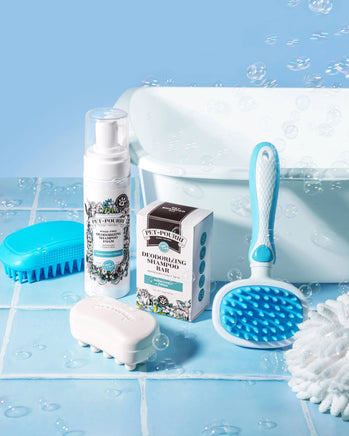 Pet grooming products including a spray bottle, soap bar, and brush on a blue tiled background.
