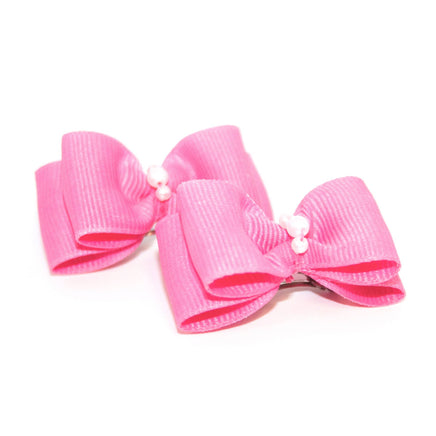 small pink bows for dogs with white pearls on a white background