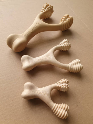 Three beige dog toys with textured design on a brown surface