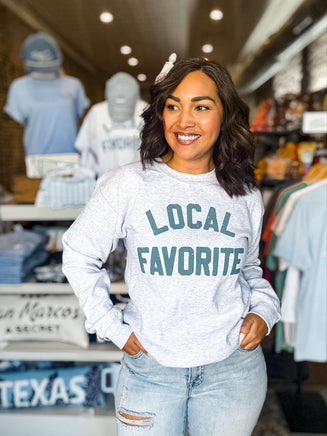 Woman wearing a 'Local Favorite' sweatshirt in a store setting