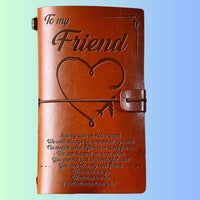 Brown leather journal with engraved text and heart design on a light blue background