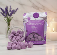 Purple bath bombs with packaging labeled 'Settle Down' on a white background