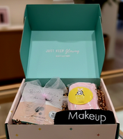 Open box containing makeup items with a visible brand name on the lid.