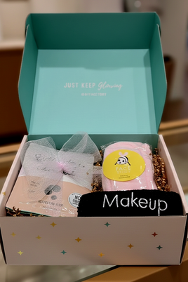 Open box containing makeup items with a visible brand name on the lid.