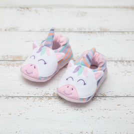 Pair of unicorn-themed children's slippers on a wooden surface