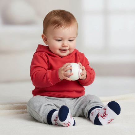 baby holding a baseball and wearing baby socks with baseball design on a white background