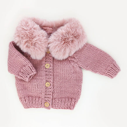 Pink knitted baby cardigan with fluffy faux fur detachable collar on a white background