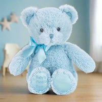 Blue teddy bear with a bow and 'Baby's First Dream' tag on a white background