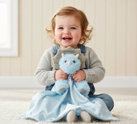 Blue dragon plush toy with a blanket on a white background