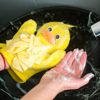 Yellow duck-shaped scrubber with a person washing hands in water