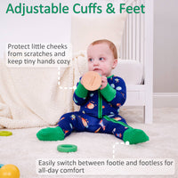 Baby wearing a colorful onesie with adjustable cuffs and feet, sitting on a carpeted floor.