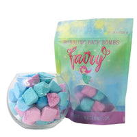 Bubbling bath bombs in a glass bowl with a colorful 'Fairy' packaging on a white background
