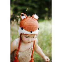 Child wearing a fox-themed knitted hat outdoors
