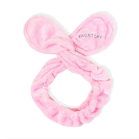 Pink bow-shaped makeup remover hairband with 'FACETORY' branding on a white background