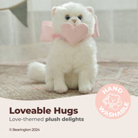 White plush toy with a pink heart bow on a neutral background, labeled 'Lovable Hugs' and 'Hand Washable'.