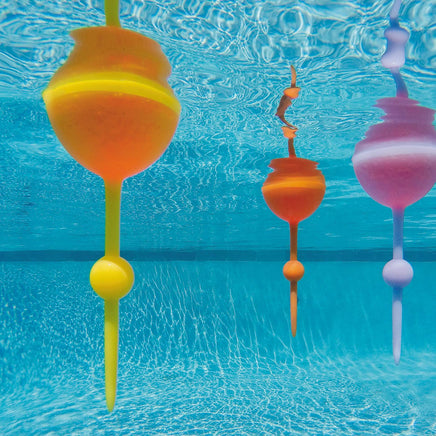 Colorful wine glasses floating in clear blue water