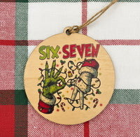 Wooden ornament with hands holding a heart and 'Six Seven' text on a plaid background