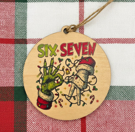 Wooden ornament with hands holding a heart and 'Six Seven' text on a plaid background
