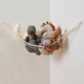 Hanging toy hammock with plush toys on a plain background