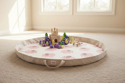 Round play mat with pink elephant pattern on a white background