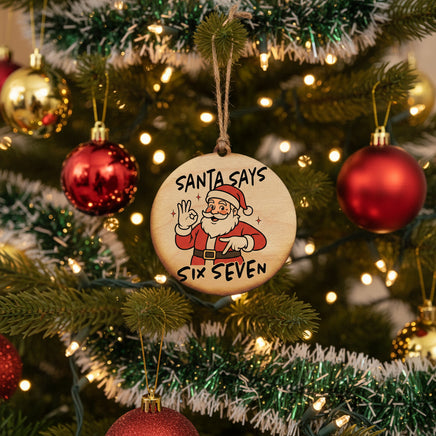 Wooden ornament with Santa Claus illustration and text 'Santa Says Six Seven' on a white background