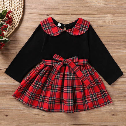 Dress with Black top with red plaid collar and skirt on a wooden surface