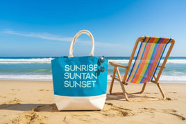 Blue tote bag with 'Sunrise Suntan Sunset' text and sunglasses on a white background