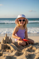 A set of heart-shaped sunglasses and a bucket hat with a pink and purple butterfly pattern. The sunglasses are attached to a card with the text 'TWEENS'.