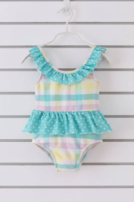little girls one-piece swimsuit with pastel colors and ruffled details on a white background
